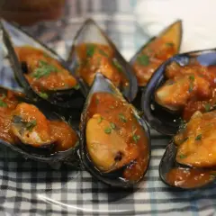 Mejillones en salsa como en los bares, servidos en sus conchas y espolvoreados con perejil fresco.
