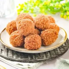Croquetas de salmón doradas y crujientes, apiladas en un plato, listas para disfrutar.