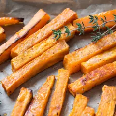Boniato crujiente hecho en air fryer, servido con ramitas de tomillo fresco.