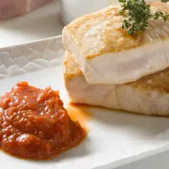 Dos jugosos medallones de atún a la plancha, con sal marina y romero, acompañados de una salsa de tomate casera.