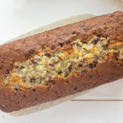 Un delicioso banana bread casero, con trozos de plátano visibles y un color dorado perfecto.