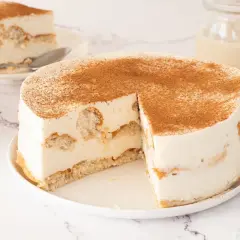 Tarta de horchata y fartons, cremosa y espolvoreada con canela. Una porción ya servida.