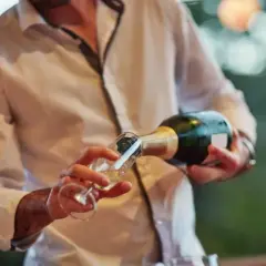 Un hombre sirve cava en una copa. El cava es un vino espumoso español, perfecto para celebraciones.