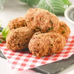 Deliciosas croquetas de atún doradas y crujientes, servidas sobre un mantel de cuadros rojos y blancos.