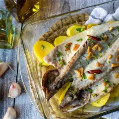 Lubina a la donostiarra horneada con patatas, ajo y guindilla. Un plato delicioso y sencillo.