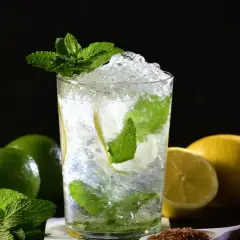 Un refrescante mojito con hielo picado, menta y rodajas de limón. Ingredientes para una mojito receta perfecta.