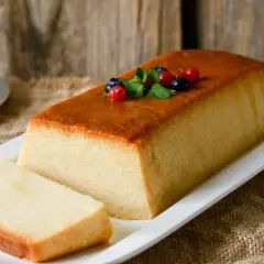 Delicioso pudin de pan casero, con una capa dorada y decorado con frutos rojos y menta. ¡Perfecto para compartir!