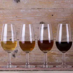 Seis copas de cristal muestran la gama de colores de los tipos de vinos de Jerez, desde el dorado pálido hasta el oscuro.