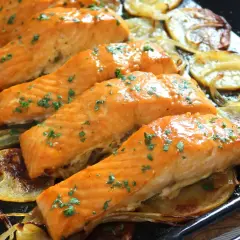 Filetes de salmón al horno, dorados y jugosos, servidos sobre patatas y cebolla asadas. Un plato delicioso y saludable.