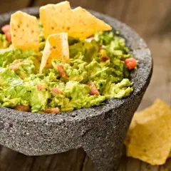 Guacamole fresco en molcajete, listo para disfrutar. Una deliciosa guacamole receta con totopos.
