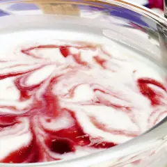 Delicioso helado de queso con remolinos de fresa en un tazón de vidrio.