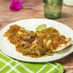 Delicioso plato de urta a la roteña, con pescado blanco cubierto de cebolla caramelizada y pimientos verdes.