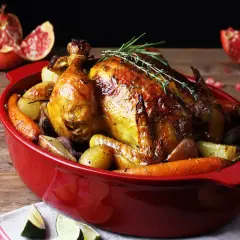 Pollo asado dorado con patatas y zanahorias, perfecto para tus recetas con pollo. Acompañado de granada y lima.