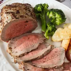 Jugoso roast beef cortado en rodajas, acompañado de brócoli al vapor y patatas asadas crujientes. Un festín para los sentidos.