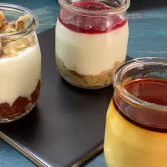 Tres postres en frascos: uno con nueces, otro con mermelada y galleta, y un flan de queso con caramelo.