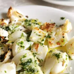 Sabrosa sepia a la plancha, cortada en trozos y aderezada con perejil fresco y aceite de oliva.