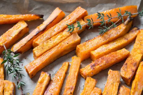 Boniato crujiente hecho en air fryer, servido con ramitas de tomillo fresco.
