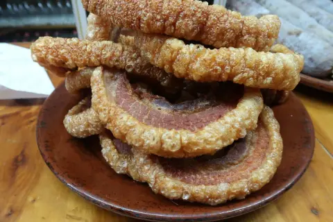 Crujientes torreznos en freidora de aire, apilados en un plato de barro. Un aperitivo irresistible.