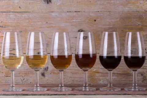 Seis copas de cristal muestran la gama de colores de los tipos de vinos de Jerez, desde el dorado pálido hasta el oscuro.