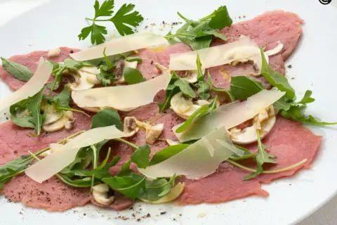 Delicioso carpaccio de ternera con champiñones, rúcula y lascas de parmesano. Un plato fresco y ligero.