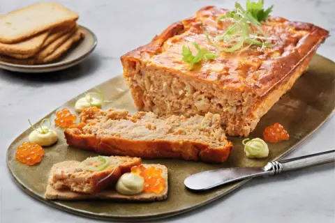 Delicioso pastel de cabracho, servido con tostadas, mayonesa y huevas de salmón.