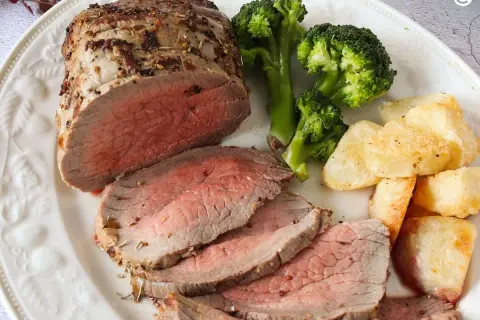 Jugoso roast beef cortado en rodajas, acompañado de brócoli al vapor y patatas asadas crujientes. Un festín para los sentidos.