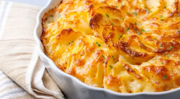 Patatas gratinadas con queso cremoso y trocitos de bacon crujiente, un plato reconfortante y delicioso.