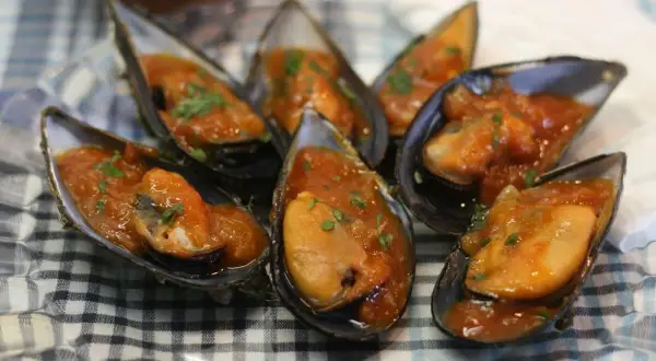 Mejillones en salsa como en los bares, servidos en sus conchas y espolvoreados con perejil fresco.