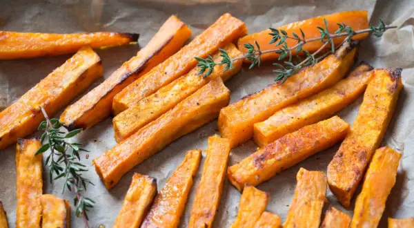 Boniato crujiente hecho en air fryer, servido con ramitas de tomillo fresco.