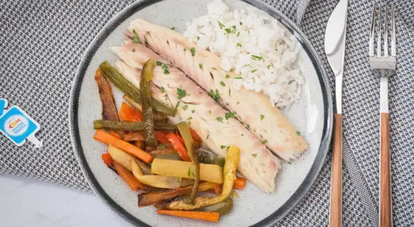 Deliciosa lubina a la sal, servida con arroz blanco y verduras asadas. Un plato saludable y lleno de sabor.