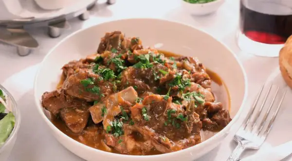 Cordero guisado, una receta tradicional llena de sabor. Tiernos trozos de carne en una salsa aromática, perfectos para compartir.
