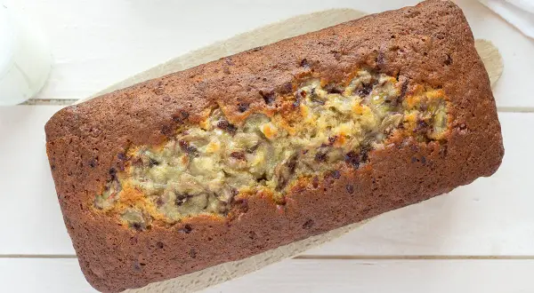 Un delicioso banana bread casero, con trozos de plátano visibles y un color dorado perfecto.