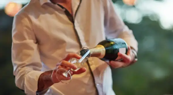 Un hombre sirve cava en una copa. El cava es un vino espumoso español, perfecto para celebraciones.
