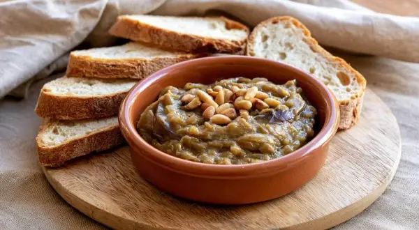 Deliciosa morcilla de verano, un paté de berenjenas cremoso con piñones, servido con rebanadas de pan rústico.