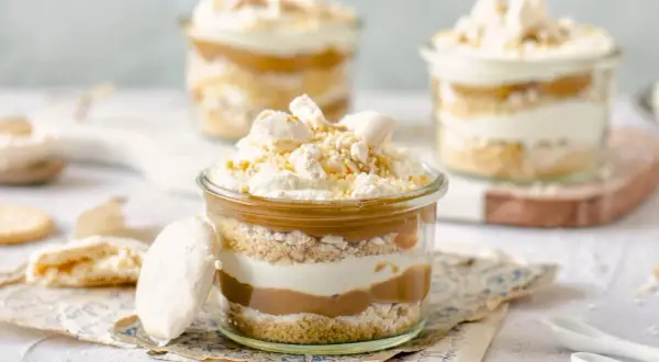 Postre en frasco con capas de galleta, crema y dulce de leche. Coronado con merengue y un toque de polvito uruguayo.