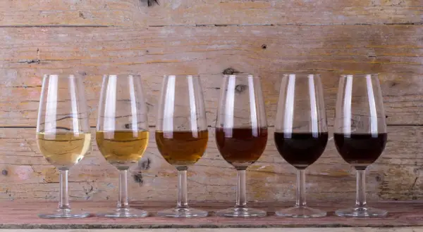 Seis copas de cristal muestran la gama de colores de los tipos de vinos de Jerez, desde el dorado pálido hasta el oscuro.