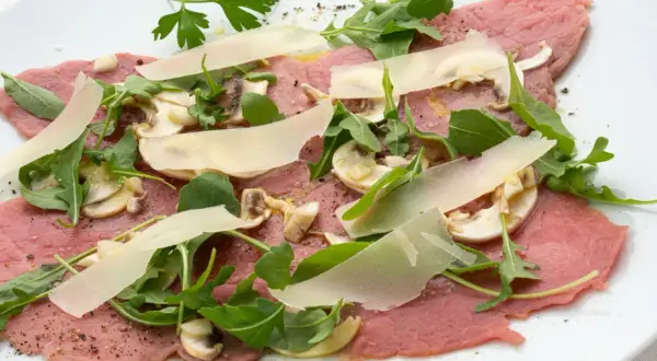 Delicioso carpaccio de ternera con champiñones, rúcula y lascas de parmesano. Un plato fresco y ligero.