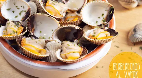 Deliciosos berberechos al vapor, recién cocidos y espolvoreados con perejil fresco. Un bocado del mar.