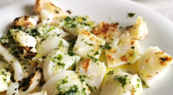 Sabrosa sepia a la plancha, cortada en trozos y aderezada con perejil fresco y aceite de oliva.