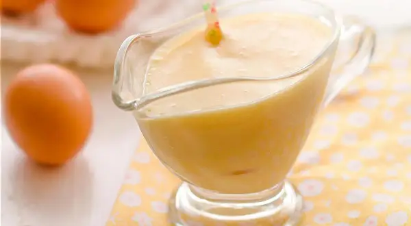 Crema pastelera lista para usar, con huevos frescos al fondo. ¡Perfecta para tu próxima receta!