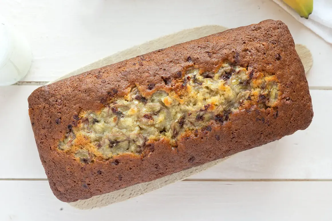 Un delicioso banana bread casero, con trozos de plátano visibles y un color dorado perfecto.