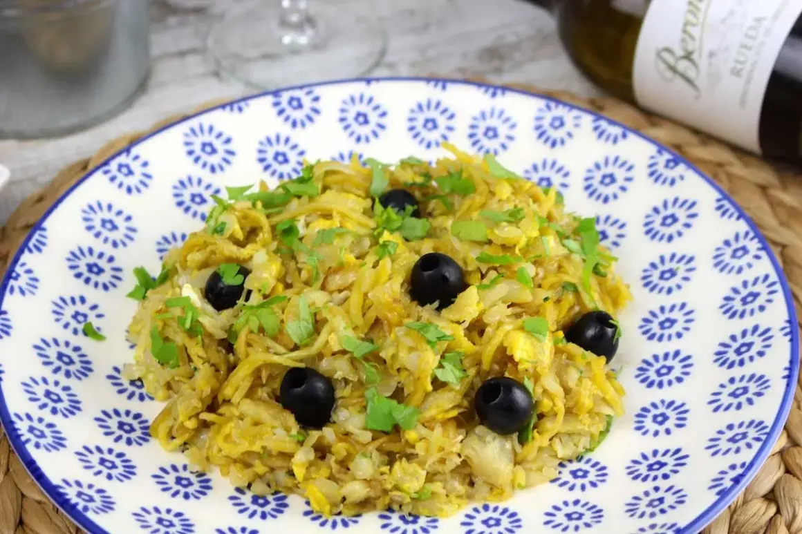 Delicioso bacalao a bras, un plato tradicional con patatas finas, huevo y aceitunas negras, espolvoreado con perejil fresco.