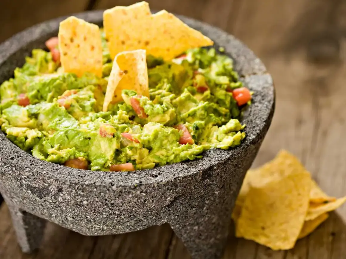 Guacamole fresco en molcajete, listo para disfrutar. Una deliciosa guacamole receta con totopos.
