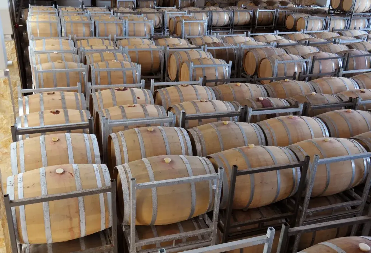 Barricas de roble apiladas, listas para la crianza del vino. As&iacute; es como se hace el vino, paso a paso.