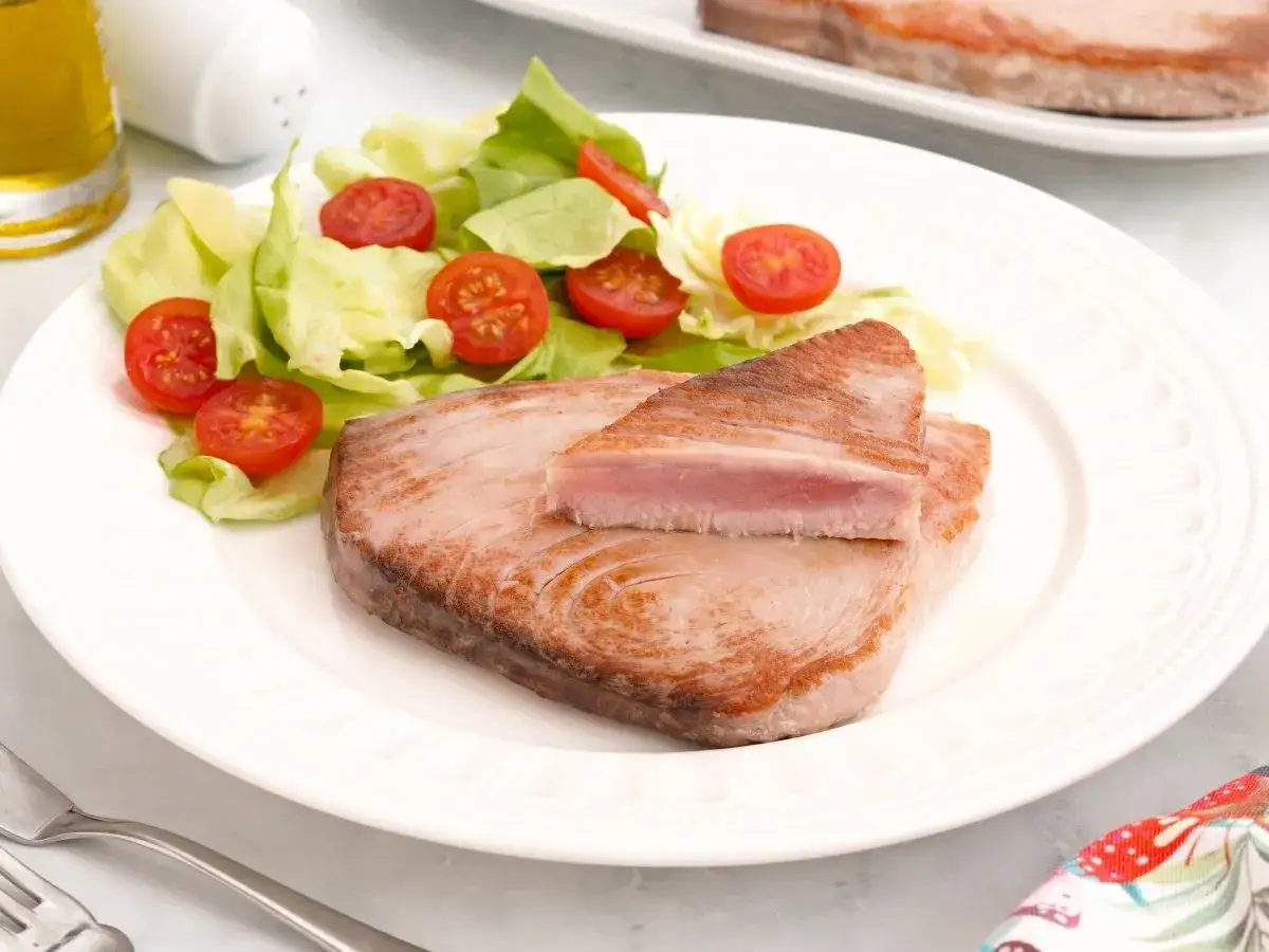 Delicioso at&uacute;n a la plancha, jugoso por dentro y dorado por fuera, servido con una fresca ensalada de lechuga y tomates cherry.