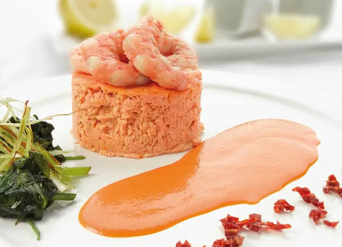 Pastel de cabracho con gambas y salsa de pimientos. Un plato elegante y sabroso.