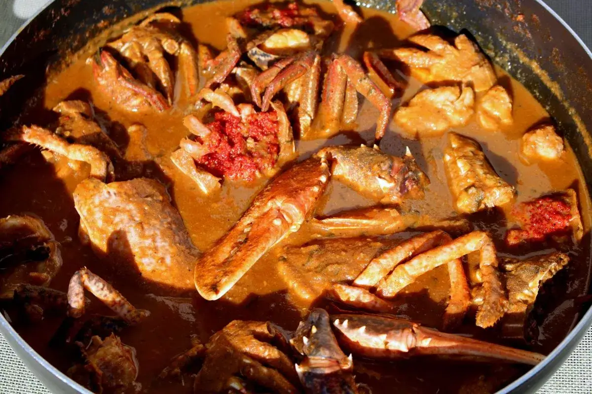 Caldereta de pescado con trozos de marisco y una salsa espesa y rojiza.