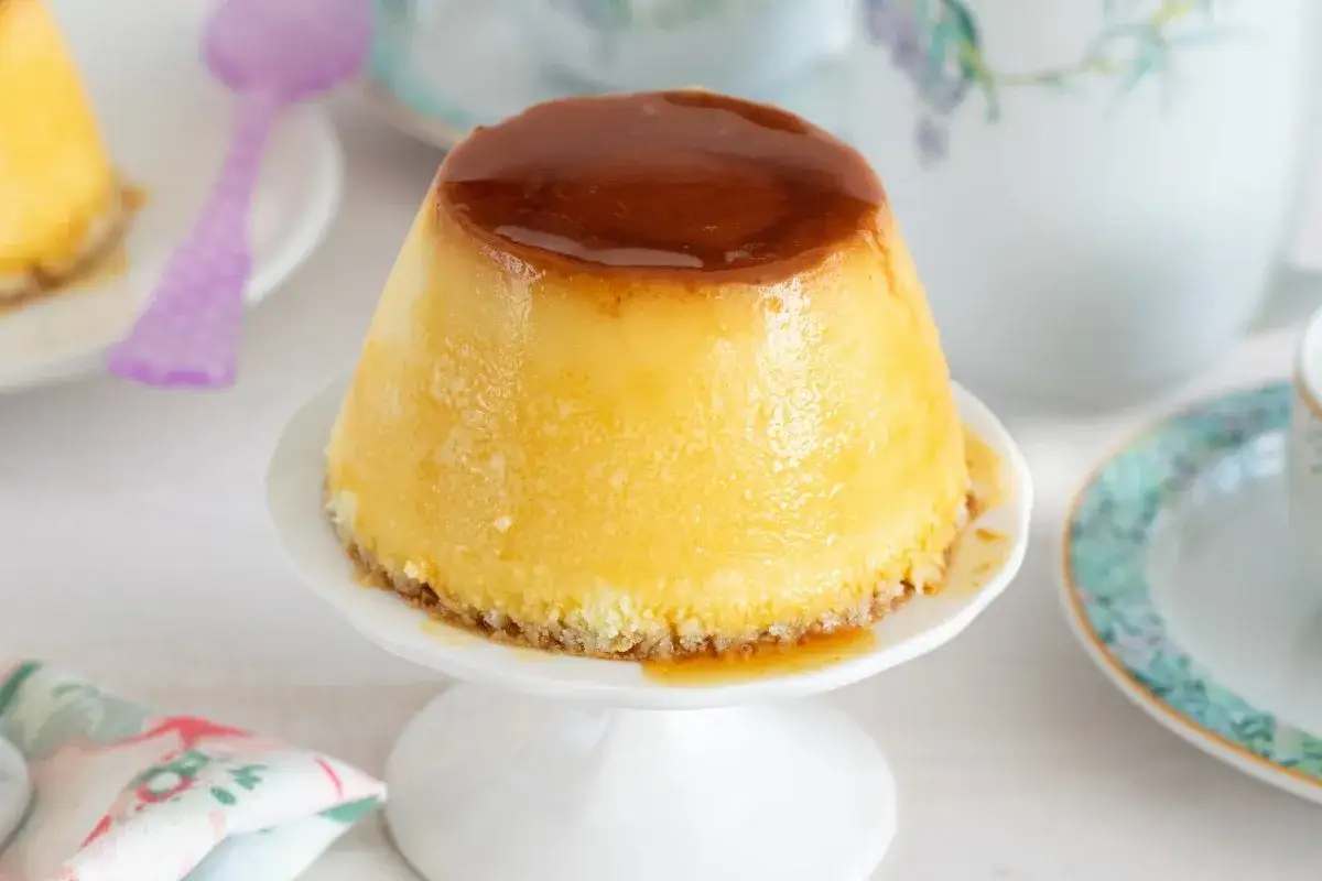 Delicioso flan de queso con caramelo l&iacute;quido, servido en un plato blanco.