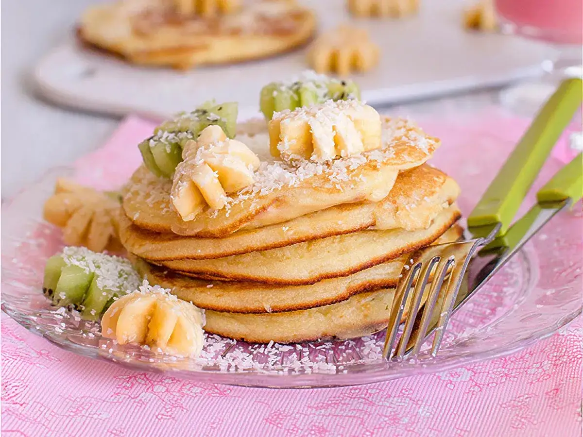 Deliciosa receta de tortitas esponjosas, decoradas con kiwi, pl&aacute;tano y coco rallado. &iexcl;Perfectas para un desayuno especial!