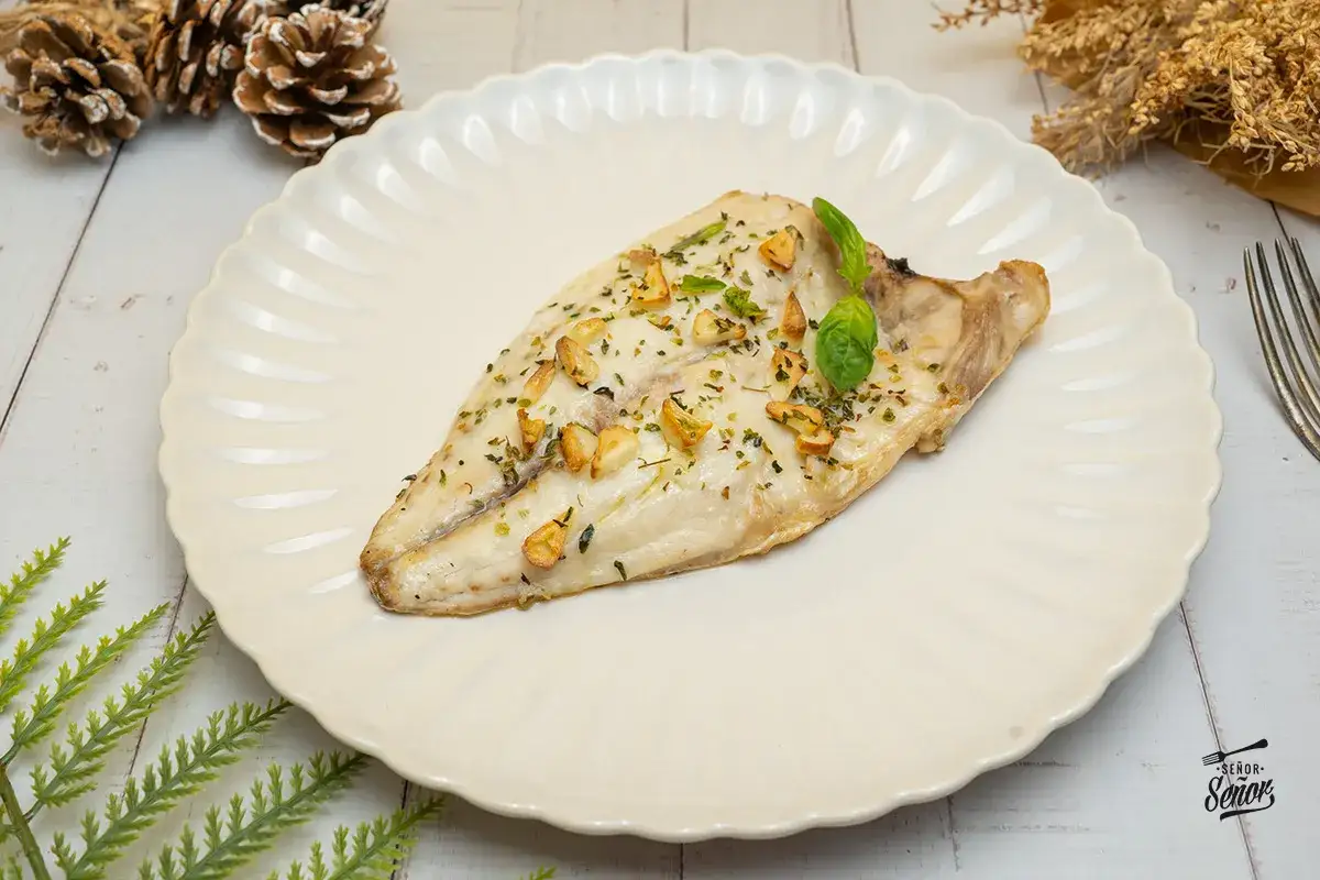 Filete de sepia en freidora de aire, con ajo y perejil, servido en plato blanco.